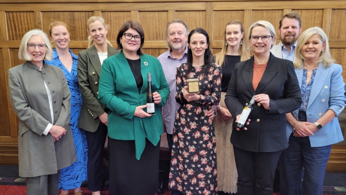 group of people from Dandelion Vineyards holding their recent award and wine bottles 